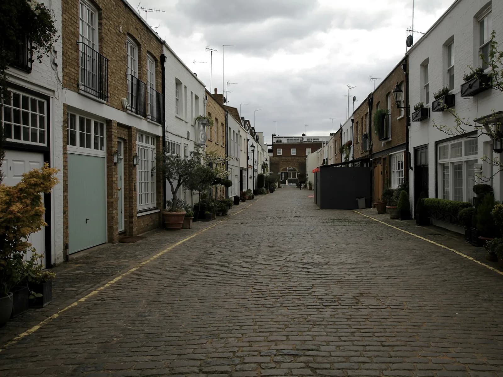 A cobbled London mews lined with converted brick and painted houses
